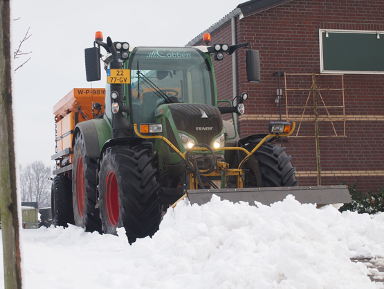 Tractor van Cobben met sneeuwschuif en strooier in de sneeuw